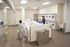 Modern apartment laundry room with bright lighting and multiple washing and drying machines, featuring residents doing laundry in a clean and organized space.