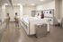 Bright, modern laundry room featuring multiple high-efficiency washers and dryers, with a convenient folding area and sleek design.