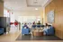 Modern communal lounge with vibrant seating, bright lighting, and an inviting laundry facility in the background.