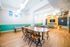 Modern recreation room featuring a stylish foosball table, spacious dining area, and cozy lounge with wood flooring and bright lighting.