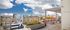 Chic urban rooftop patio with cozy seating, wooden deck, and stunning city skyline views.