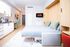 Modern studio apartment with a sleek kitchenette, stylish interiors, and a cozy Murphy bed design for space-saving luxury.