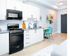 Modern kitchen with sleek white cabinets, stylish black appliances, and a cozy dining area with vibrant teal chairs.