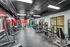 Modern fitness center with an array of advanced gym equipment and vibrant red accent wall, offering a dynamic workout environment.