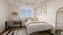 Bright and cozy bedroom with a modern desk area, large window for natural light, and stylish decor, perfect for a peaceful retreat.