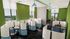 Modern co-working space with individual workstations, vibrant green walls, and panoramic window views.