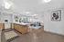 Modern open-concept apartment showcasing a chic kitchen with wood cabinets and a cozy living area with stylish decor.