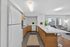 Contemporary open-concept kitchen and living area with sleek cabinetry, bright lighting, and welcoming lounge space.