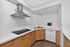 Elegant contemporary kitchen with sleek stainless steel range hood, modern cabinetry, and integrated appliances.