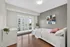 Bright and modern bedroom with a large window, wooden floor, and stylish decor, offering a cozy and comfortable space.