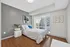 Bright and modern bedroom with large windows, stylish decor, and city view, perfect for urban living.