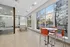 Bright, modern lounge area with large windows, a ping pong table, and vibrant orange chairs, perfect for relaxation and socializing.