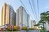 Vibrant urban scene featuring modern high-rise apartments with large windows, nestled on a tree-lined street, creating an ideal city living experience.