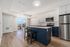 Modern open-concept kitchen and living area with sleek stainless steel appliances, elegant cabinetry, and sunlit balcony views.