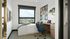 Bright and modern bedroom with a large window view, cozy workspace, and stylish decor, perfect for comfort and productivity.