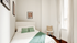 Cozy bedroom with modern decor, featuring a comfortable bed, stylish artwork, and a bright window with elegant curtains.