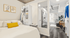 Bright and modern bedroom with cozy bed, stylish decor, and open view towards a chic living area with large windows and elegant furniture.