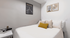 Cozy modern bedroom featuring stylish decor, soft pillows, and elegant art prints.