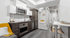 Modern kitchen with sleek appliances, cozy nook, and stylish open layout leading to a bright bedroom.
