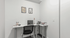 Modern home office nook with a sleek white desk, ergonomic chair, stylish art decor, and ambient lighting.