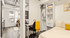Modern studio apartment featuring a cozy bedroom with open shelving, a stylish workspace, and abundant natural light.