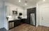 Modern kitchen with sleek cabinetry, stainless steel appliances, and stylish wood flooring, offering a chic and functional cooking space.