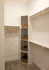 Elegant walk-in closet with modern shelving, wicker baskets, and ample hanging space, perfect for organizing in style.