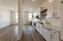 Elegant apartment showcasing a modern kitchen with sleek cabinetry, open living area, and stylish wood flooring.