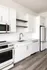 Sleek modern kitchen featuring stainless steel appliances, elegant white cabinetry, and chic open shelving.
