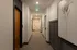 Inviting apartment hallway featuring elegant artwork, modern lighting, and a stylish wooden door.