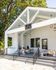 Charming outdoor patio with modern seating area and stylish hanging lights, perfect for social gatherings.