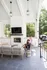 Charming outdoor living space with cozy seating, modern gas fireplace, and beautiful greenery, perfect for relaxation and entertaining.