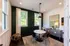 Chic meeting or work from home space with a round marble table, elegant chairs, and modern decor, featuring large windows and stylish lighting.