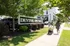 Inviting scene at Devine District with people enjoying a sunny stroll, showcasing lush landscaping and modern amenities.