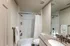 Elegant bathroom featuring a granite countertop, sleek fixtures, and a pristine bathtub with shower curtain, exuding a modern and inviting atmosphere.
