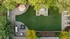 Elegant aerial view of a lush green courtyard featuring a cozy seating area, modern outdoor furniture, and vibrant landscaping under shady trees.