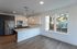 Modern kitchen with sleek cabinetry, stainless steel appliances, and a chic island overlooking a bright window with city mural views.