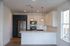Elegant modern kitchen featuring sleek slate appliances, white cabinetry, and chic pendant lighting.