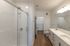 Elegant modern bathroom featuring a sleek double vanity, spacious glass-enclosed shower, and bright lighting.