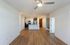 Bright modern apartment interior with open-floor plan, featuring a sleek kitchen area and elegant wooden flooring.