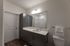 Sleek modern bathroom with elegant cabinetry, large mirror, and a comfortable shower area.