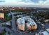 Stunning aerial view of vibrant cityscape featuring modern apartments, lush greenery, and a picturesque river.