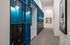 Contemporary apartment hallway showcasing elegant mailboxes with vibrant blue panel accents and stylish lighting.