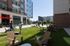 Modern urban apartment courtyard featuring stylish outdoor seating and vibrant green space, perfect for relaxation and socializing.