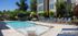 Luxurious outdoor pool area with comfortable lounge chairs, modern apartment building backdrop, and refreshing aquatic amenities.