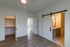 Modern bedroom featuring stylish sliding barn doors leading to a chic bathroom and spacious walk-in closet, with elegant wood flooring and natural light.