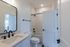 Modern bathroom with sleek fixtures, elegant vanity, and a stylish bathtub, offering a serene retreat in your home.