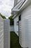 Charming outdoor corridor with sleek white siding and lush artificial grass welcomes you to modern living.