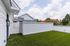Charming outdoor space with lush green artificial turf and modern white privacy fencing, perfect for relaxation and entertainment.