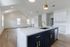 Elegant open-concept living area with vaulted ceilings, modern kitchen island with stylish fixtures, and abundant natural light.